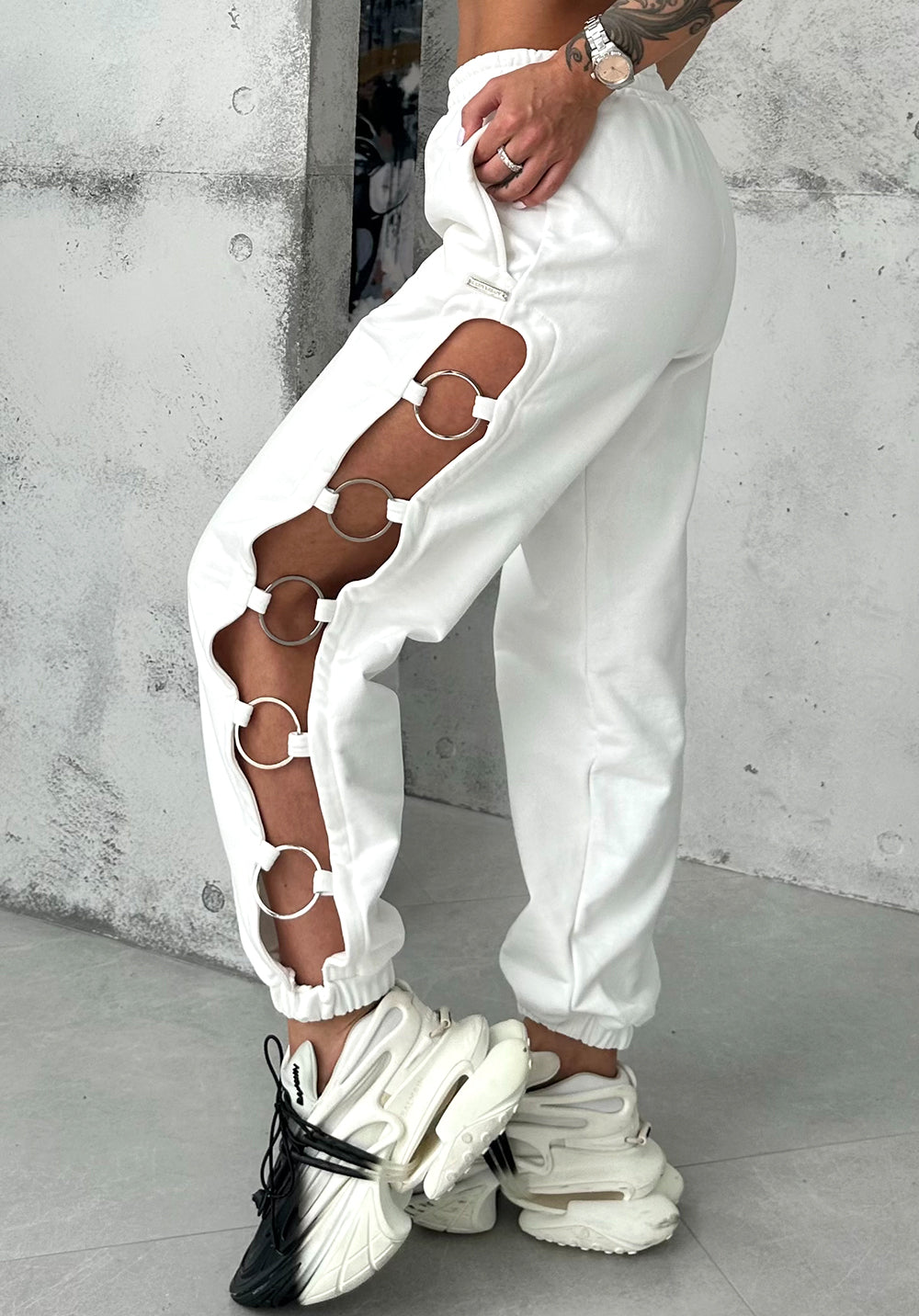 White cut-out joggers by KRUTYAKOV with five-ring side details and relaxed high-waist fit