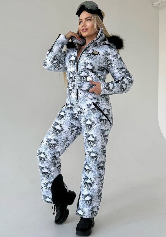 Women’s one piece ski suit by KRUTYAKOV with black and white skull print, fitted silhouette, and detachable fur hood