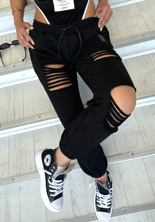 RAGGED black distressed jogger pants with ripped cut-out details and relaxed streetwear fit