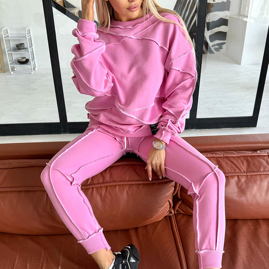 Women’s pink reverse seam tracksuit by KRUTYAKOV — Inva two piece set with bold white exposed stitching and relaxed designer fit