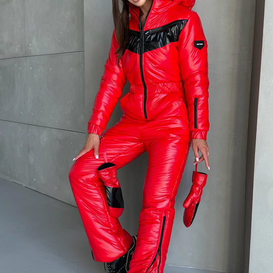 Woman in SANTA red insulated ski jumpsuit by KRUTYAKOV styled as a bold luxury winter outfit