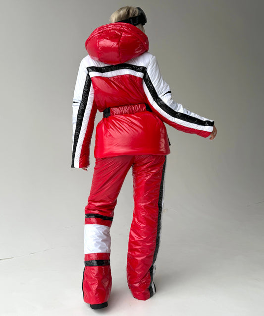 Full-body view of FREYA red ski suit with glossy jacket, matching pants, and flattering feminine silhouette