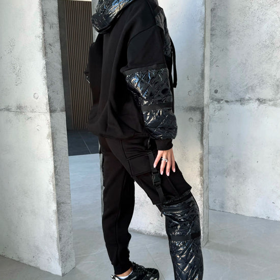 Black warm tracksuit for women with zip-up jacket, matching joggers, silver zipper, and premium tailored silhouette