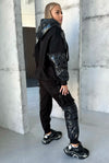 Black warm tracksuit for women with zip-up jacket, matching joggers, silver zipper, and premium tailored silhouette