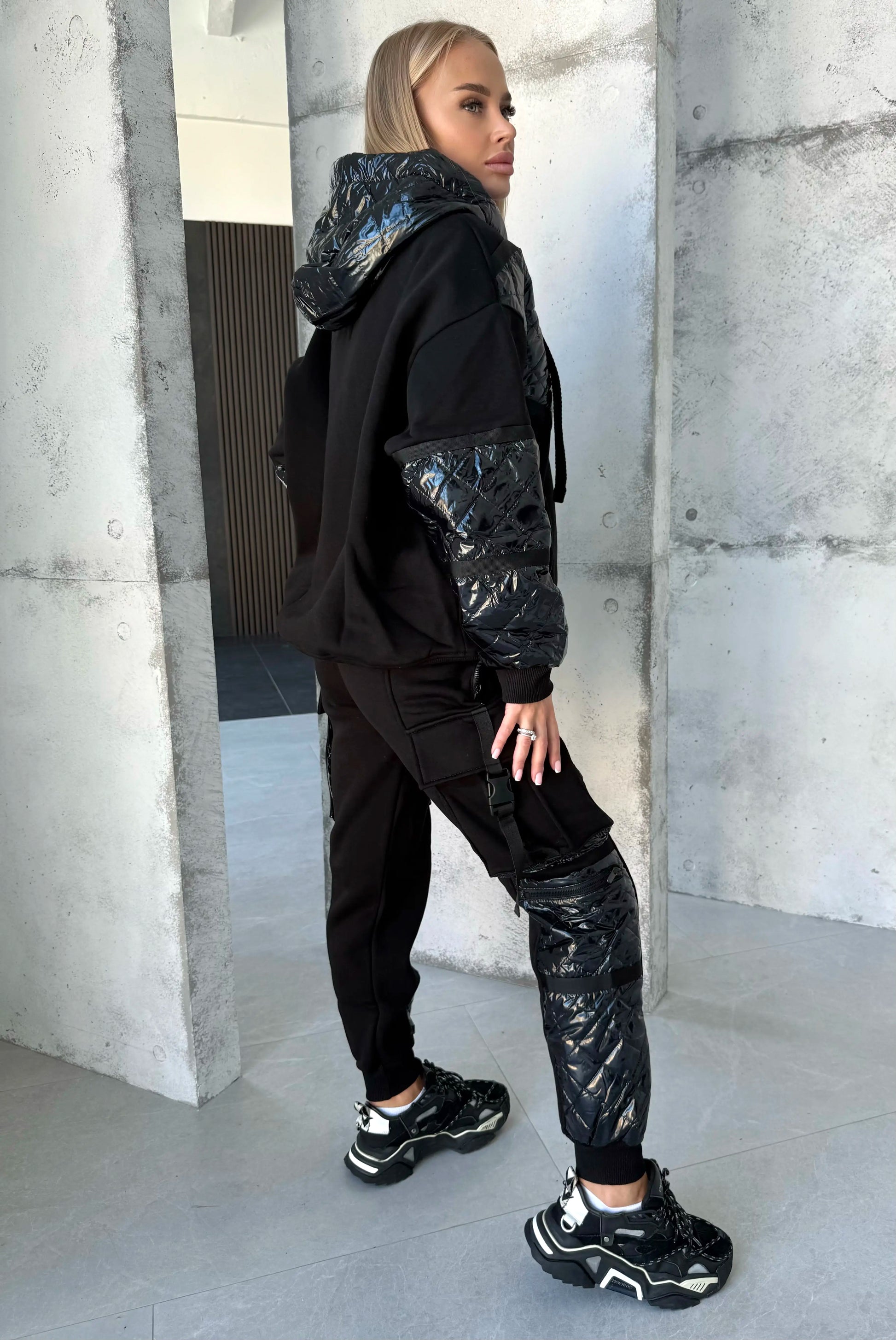 Black warm tracksuit for women with zip-up jacket, matching joggers, silver zipper, and premium tailored silhouette