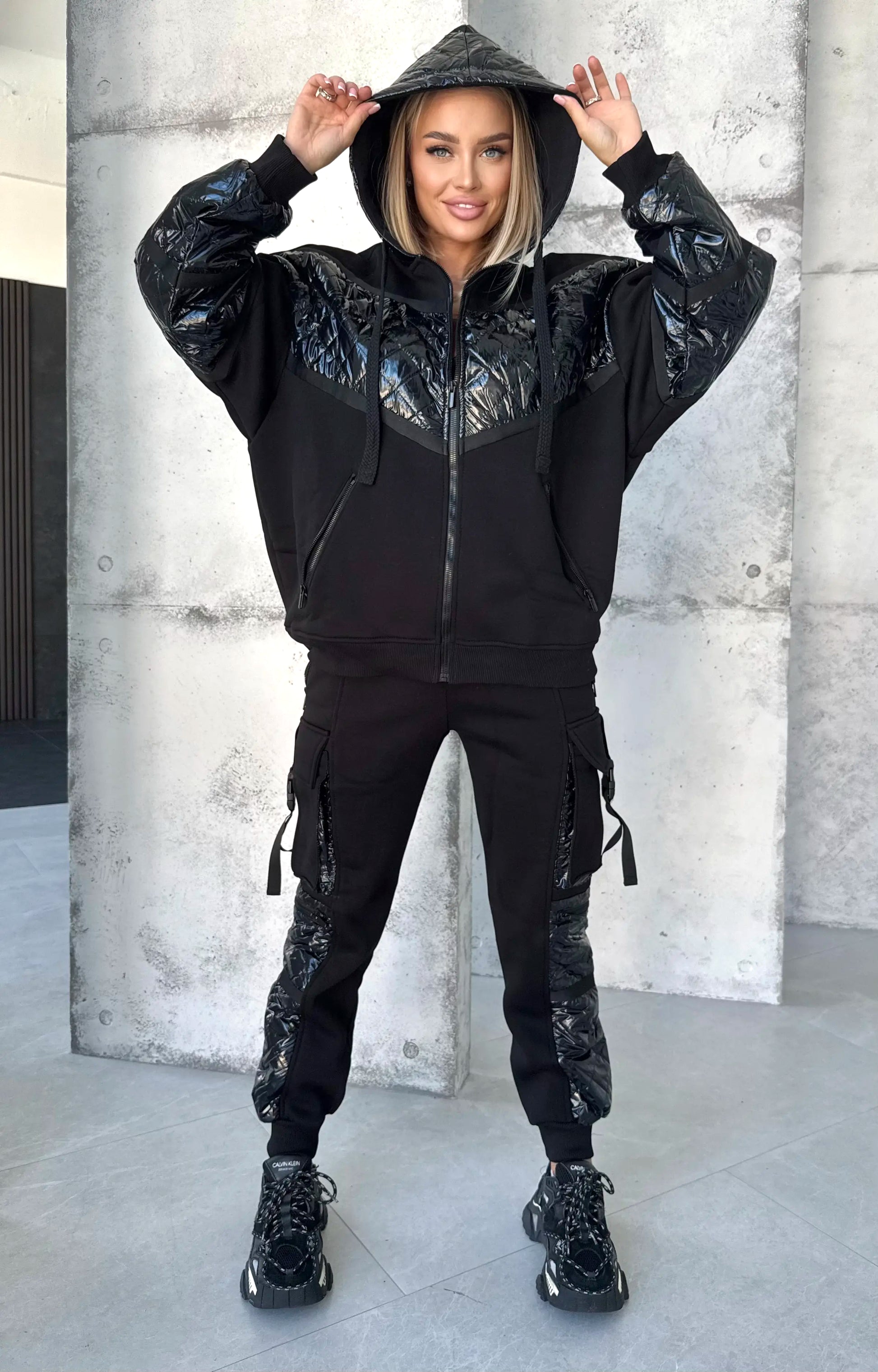 Women’s black two piece tracksuit with glossy finish, soft micro-fleece lining, and comfortable jogger fit