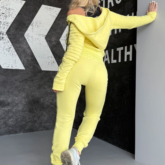 Side view of yellow KRUTYAKOV Relief tracksuit showing fitted joggers, zip pockets, and bold casual styling