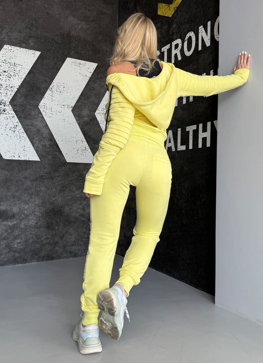 Side view of yellow KRUTYAKOV Relief tracksuit showing fitted joggers, zip pockets, and bold casual styling