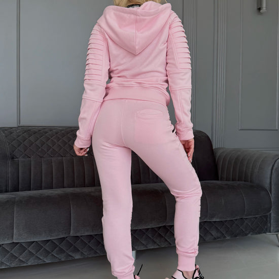 Women’s pastel pink two-piece tracksuit by KRUTYAKOV with zip hoodie, matching joggers, and relaxed fit