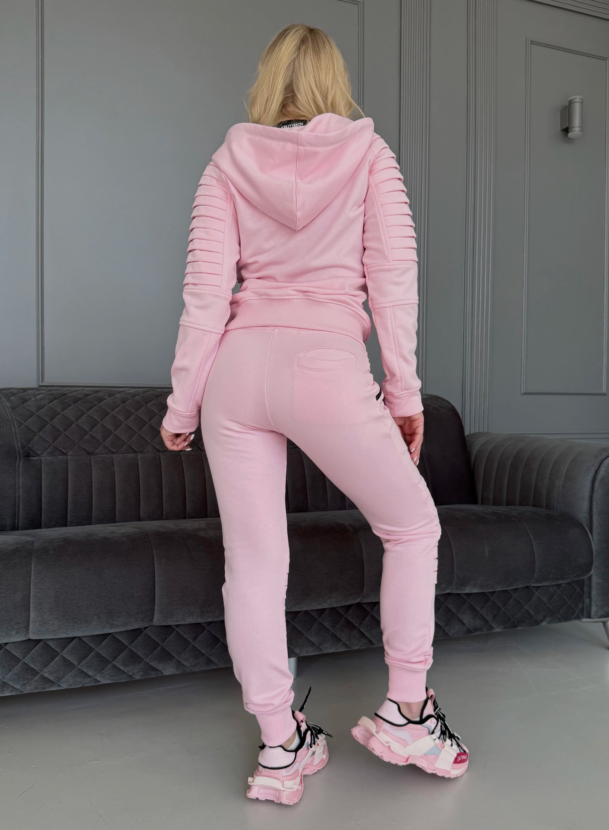 Women’s pastel pink two-piece tracksuit by KRUTYAKOV with zip hoodie, matching joggers, and relaxed fit