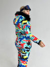 Back view of women’s one piece ski suit with multicolored print, detachable hood, and comfortable winter fit