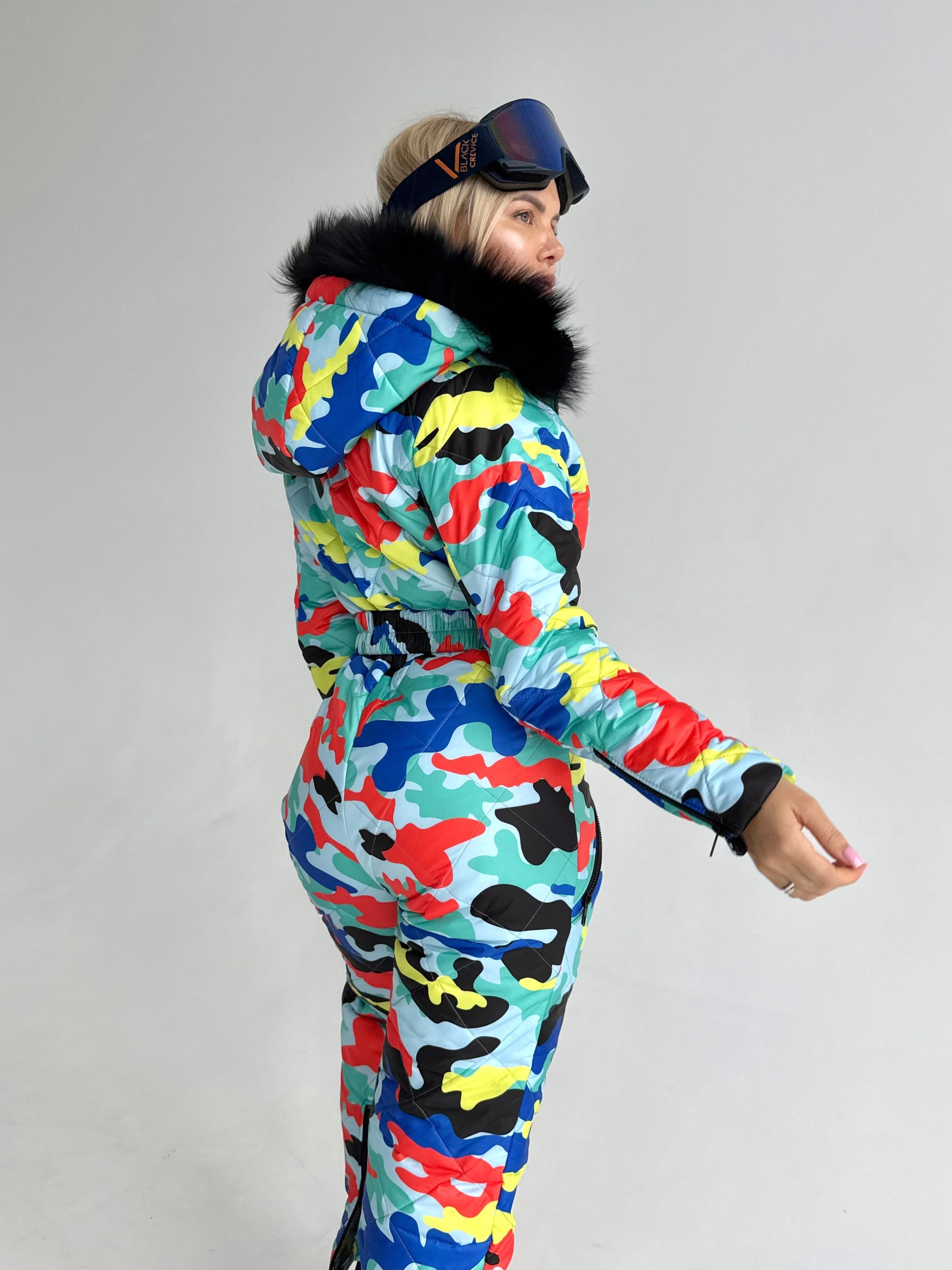 Back view of women’s one piece ski suit with multicolored print, detachable hood, and comfortable winter fit