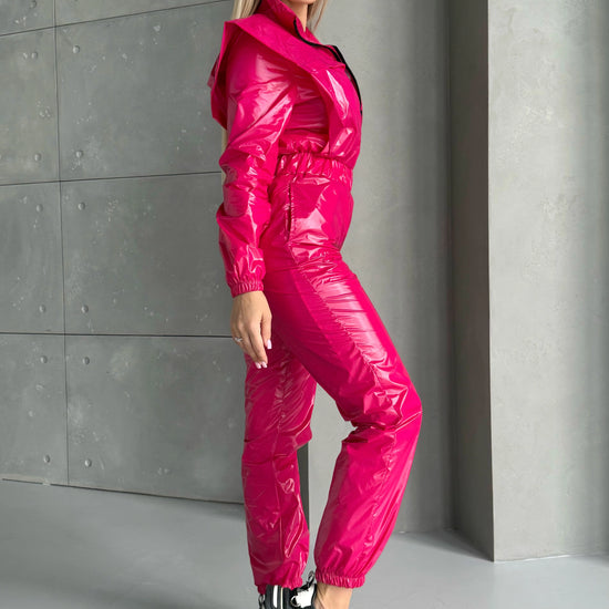 Side view of hot pink shiny jumpsuit with sleek body-contouring fit