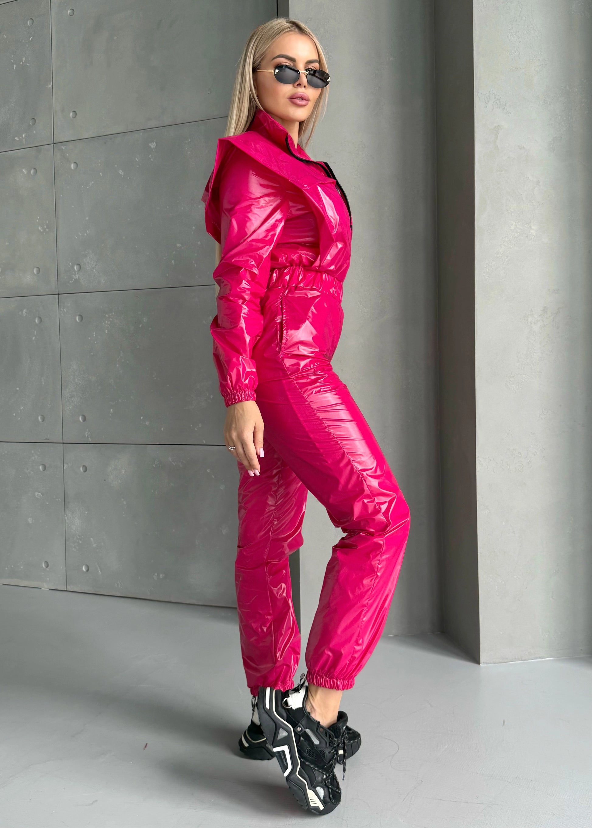 Side view of hot pink shiny jumpsuit with sleek body-contouring fit