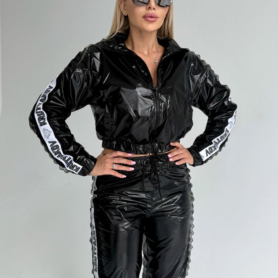 Women’s glossy black two piece tracksuit with branded side stripes and fitted streetwear silhouette