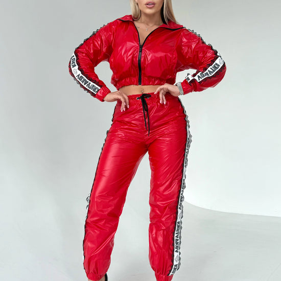 Women’s glossy red two-piece tracksuit with black lace side details and sporty chic silhouette