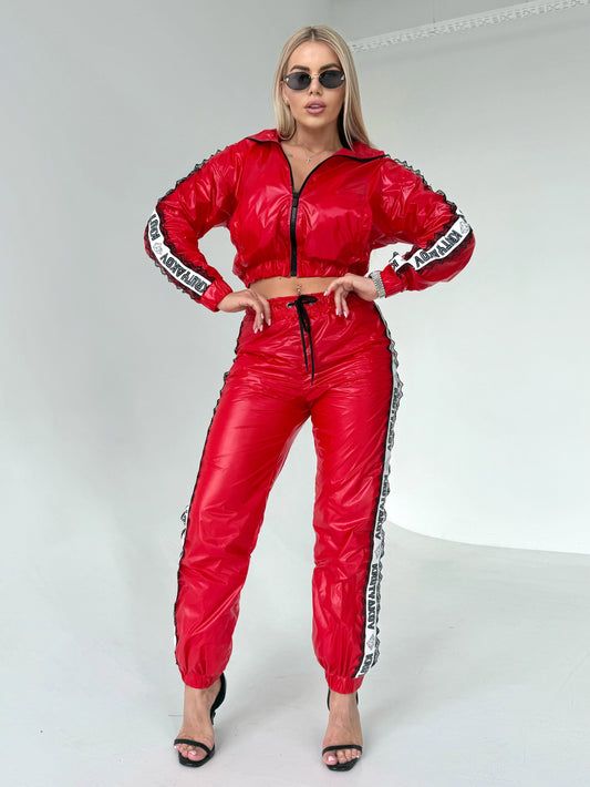 Women’s glossy red two-piece tracksuit with black lace side details and sporty chic silhouette
