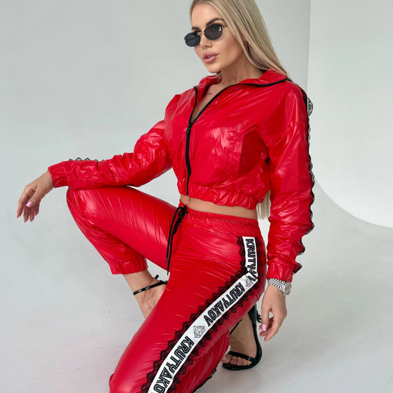 Women’s shiny red tracksuit with branded side stripes, mesh lining, and comfortable fitted silhouette