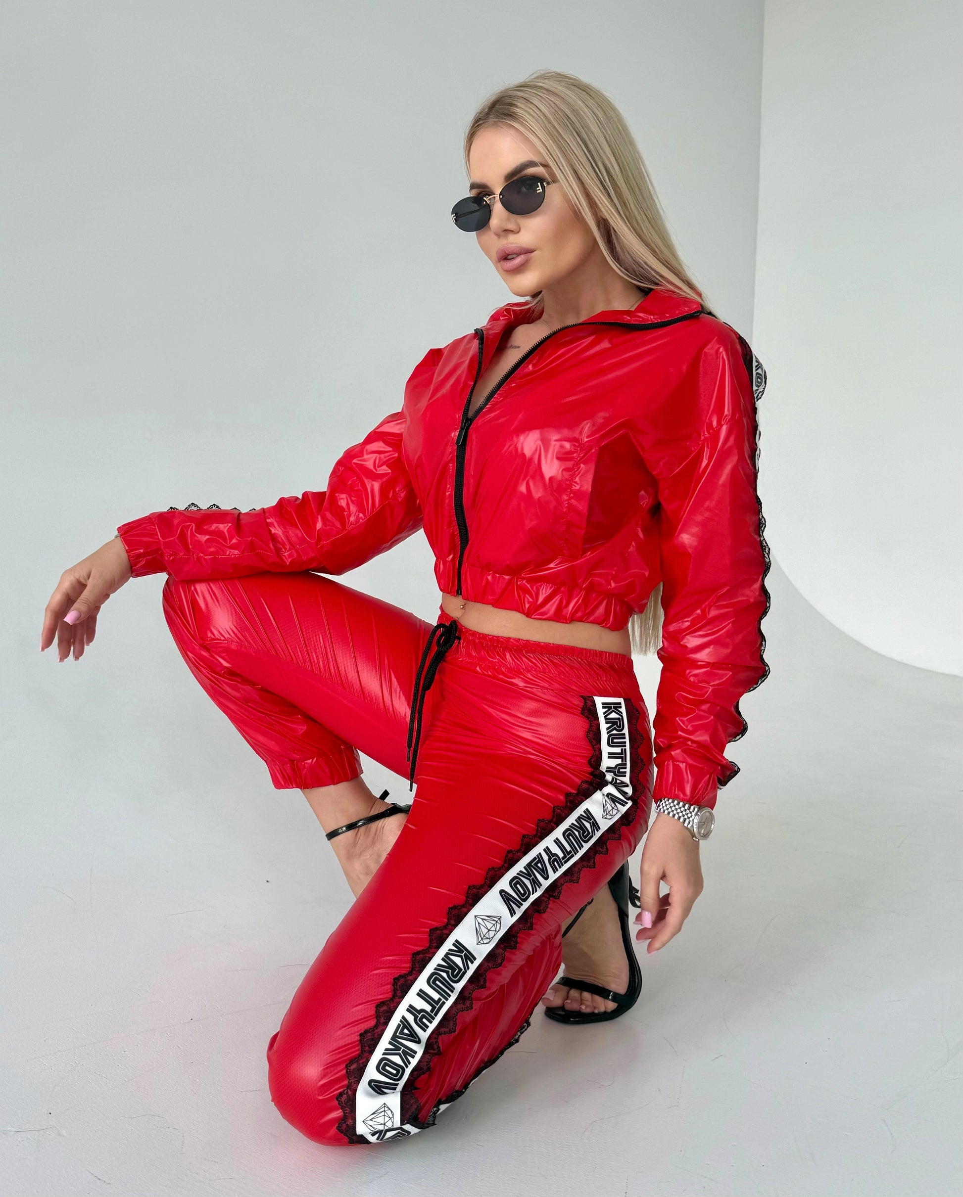 Women’s shiny red tracksuit with branded side stripes, mesh lining, and comfortable fitted silhouette