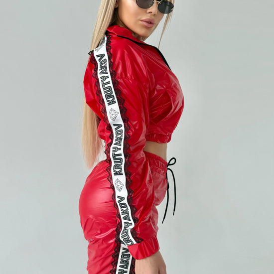 Bold red women’s two-piece streetwear set with high-shine finish and luxury sporty aesthetic