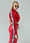 Bold red women’s two-piece streetwear set with high-shine finish and luxury sporty aesthetic