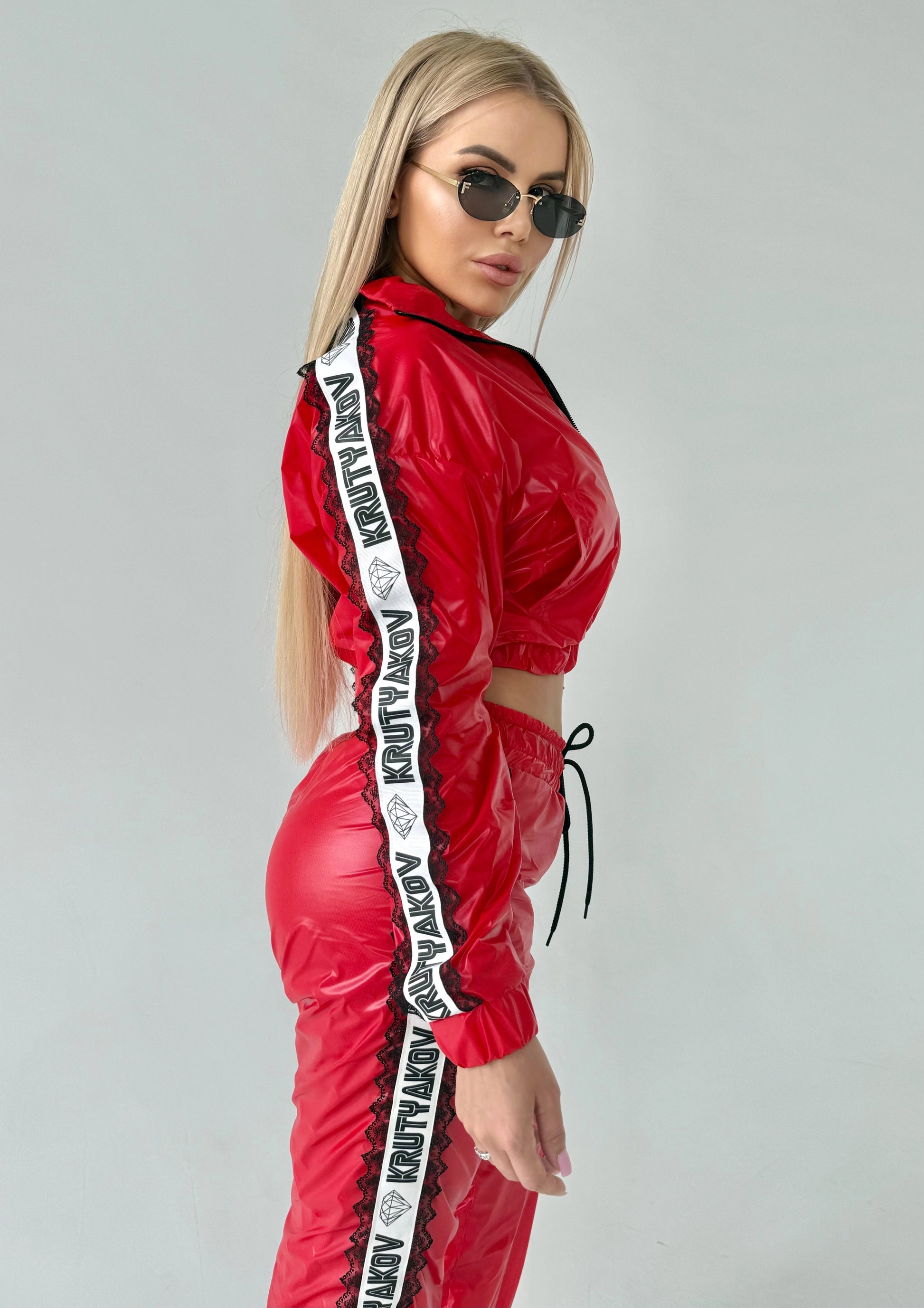 Bold red women’s two-piece streetwear set with high-shine finish and luxury sporty aesthetic