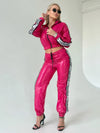 Luxury fuchsia glossy tracksuit for women with high-waisted joggers, cropped jacket, and bold athleisure style