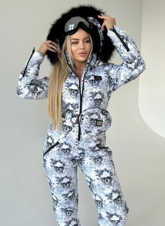 Full-body view of women’s black white skull ski suit with belt bag, hood, and winter-ready one-piece design
