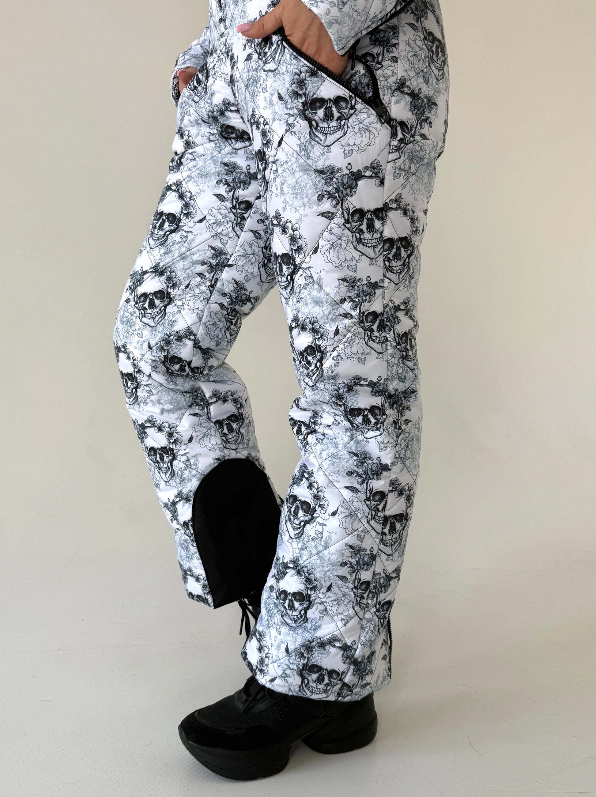 Women’s black white skull snowsuit styled for ski resorts, snowboarding trips, and winter mountain vacations