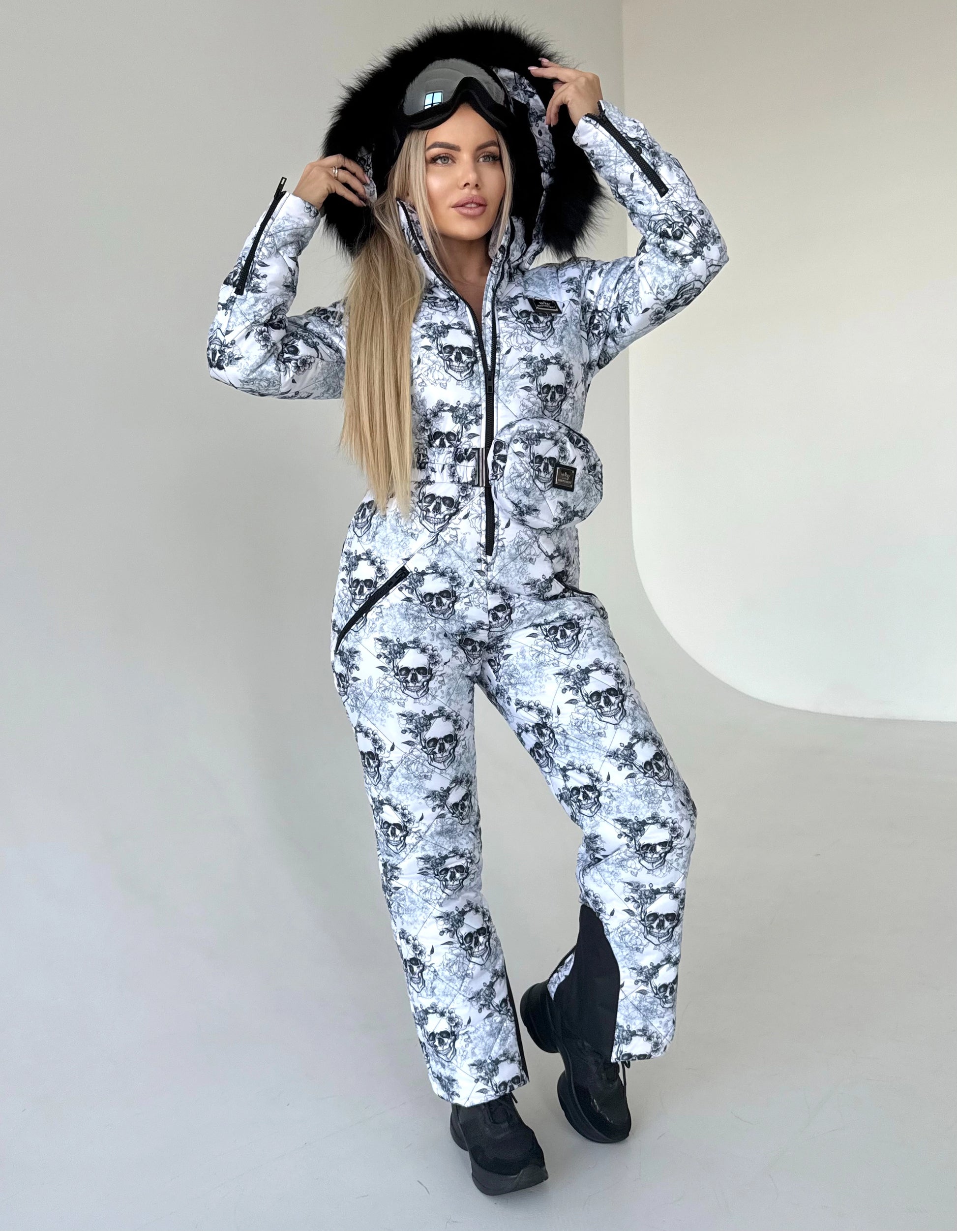 Back view of KRUTYAKOV one piece ski suit with detachable hood, belt bag, and bold designer print
