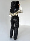 Full-body view of KRUTYAKOV black and gold ski suit with fitted silhouette, waist belt, and premium winter construction