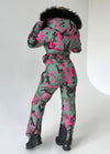 Full-body view of VALE pink camouflage snowsuit with fitted silhouette, insulated construction, and belt bag
