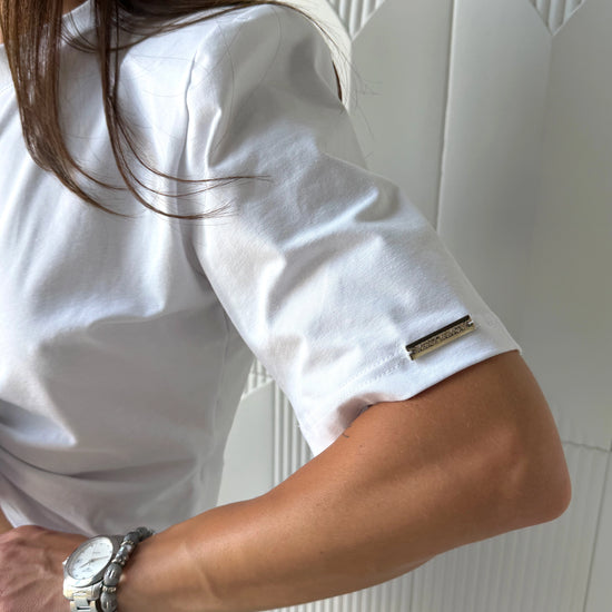 Women’s white cotton stretch t-shirt with ROSETTE front detail, styled with high-waisted denim shorts