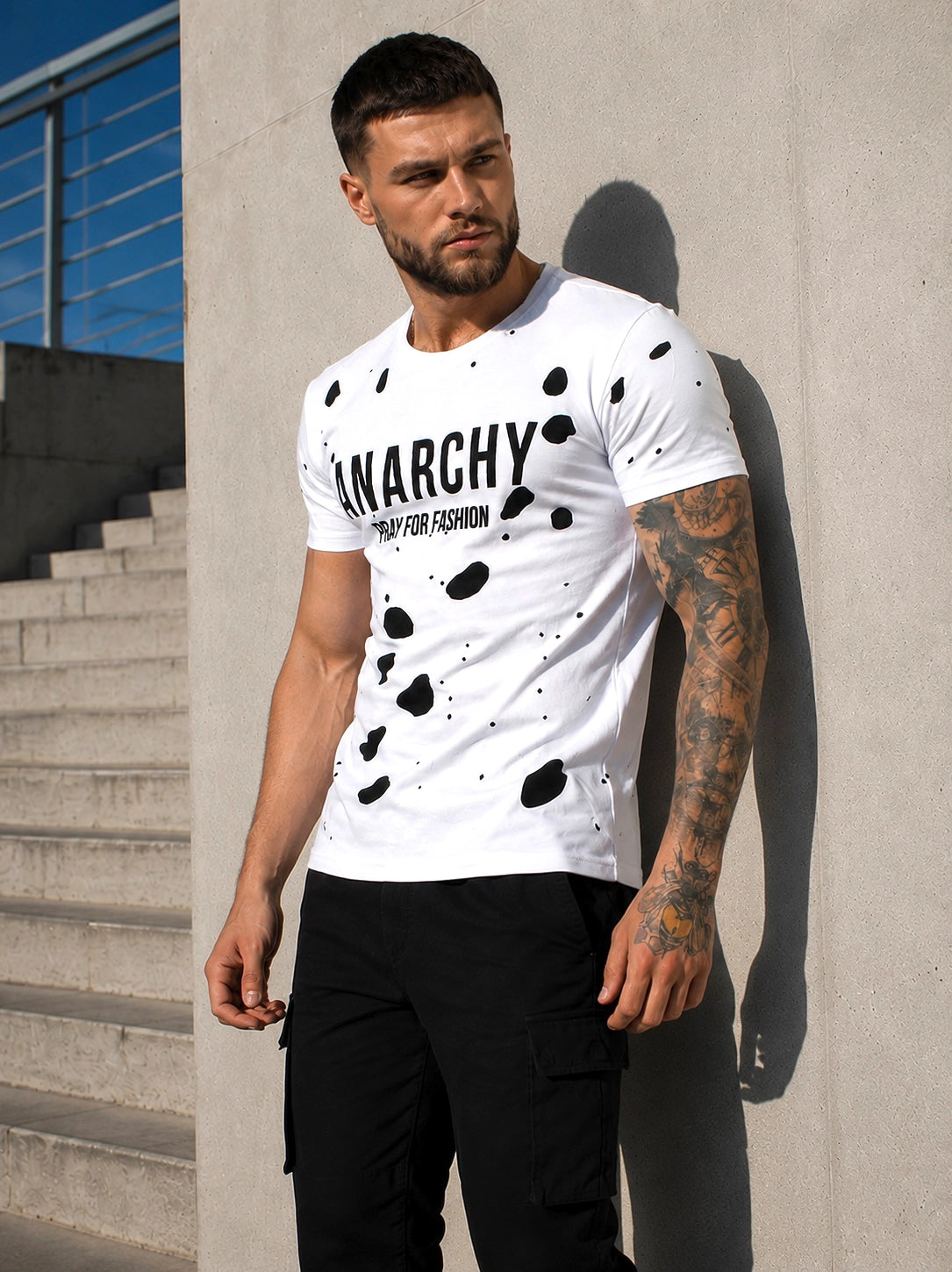 Close-up of men’s white designer T-shirt with ANARCHY velvet-effect print and layered cut-out design