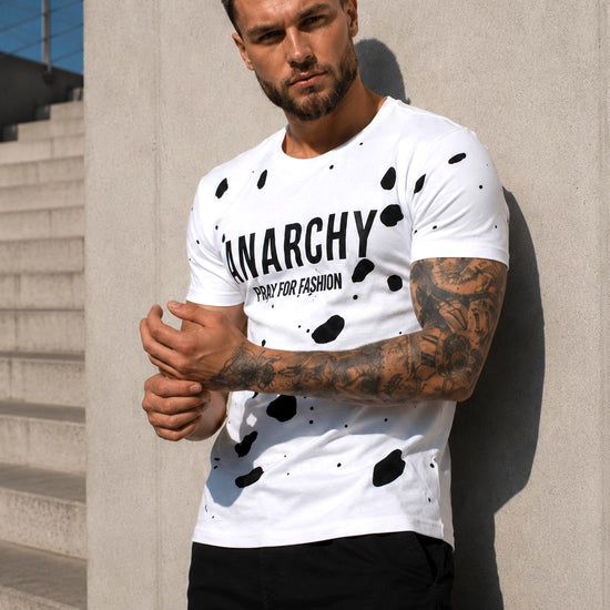 Men’s streetwear outfit with white KRUTYAKOV ANARCHY T-shirt, black cargo pants, and sneakers
