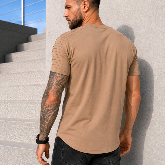 Back view of men’s beige SAINTS T-shirt with asymmetric hem and premium casual fit