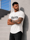 Male model wearing an off white SAINTS graphic T-shirt with black jeans in an urban casual outfit