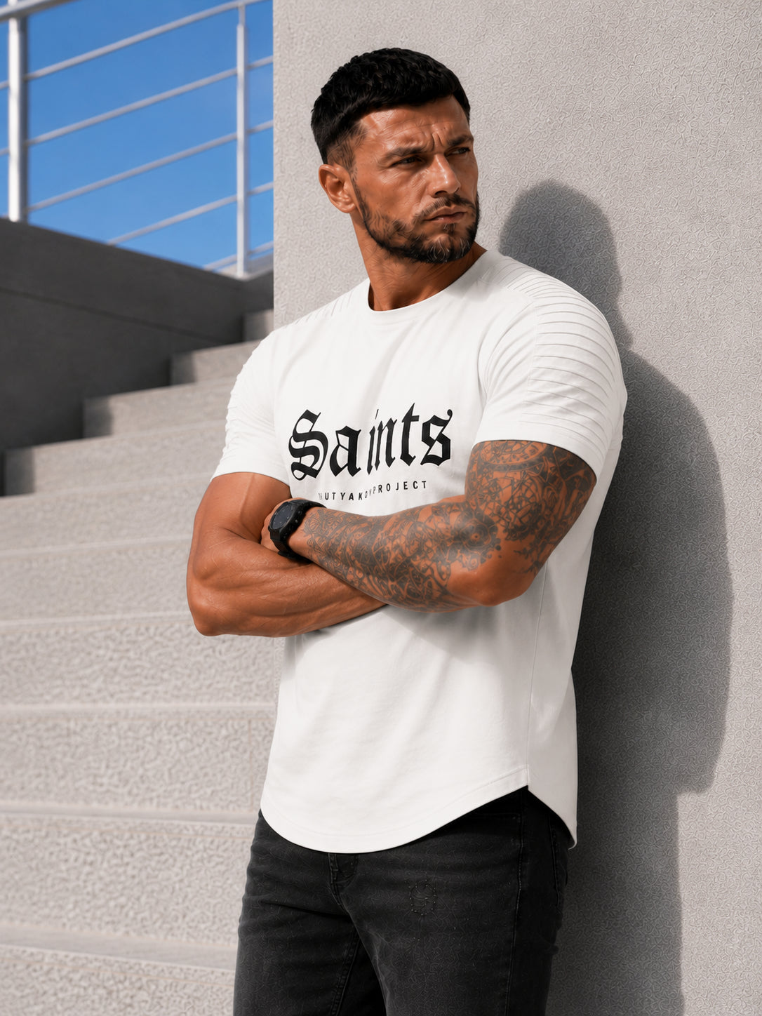 Male model wearing an off white SAINTS graphic T-shirt with black jeans in an urban casual outfit