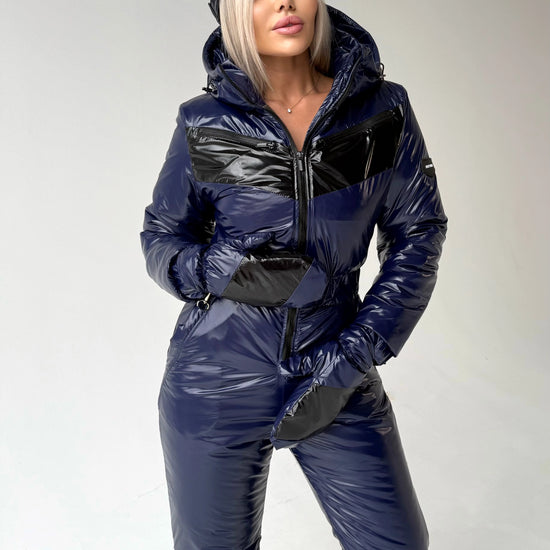 Full-body dark blue ski jumpsuit for women with hood, matching gloves, and sleek winter silhouette