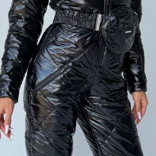 Black glossy ski suit detail with adjustable waist belt and zip pockets