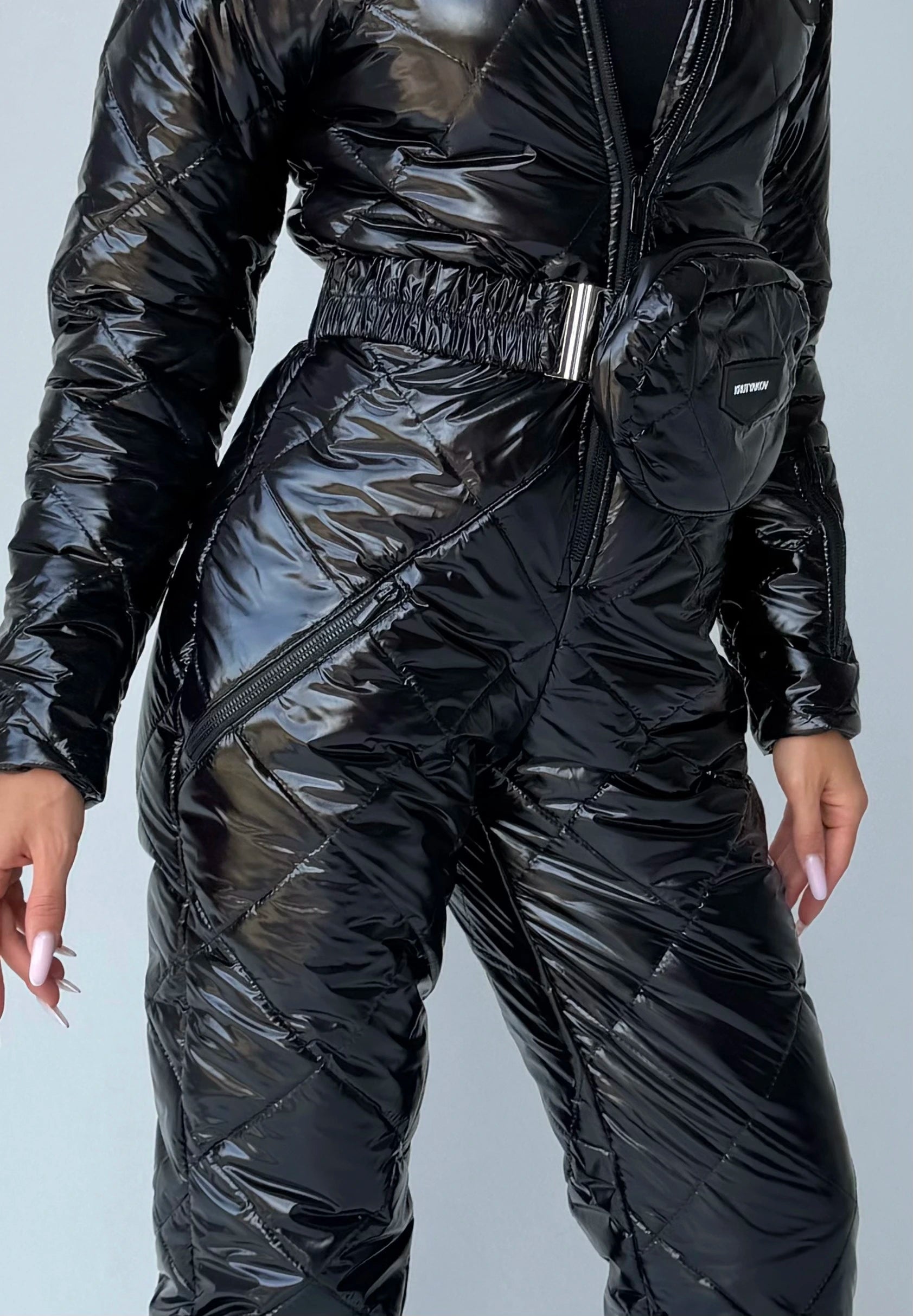 Black glossy ski suit detail with adjustable waist belt and zip pockets