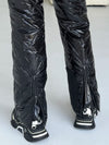 Rear ankle zippers on women’s black ski suit for easier fit over ski boots
