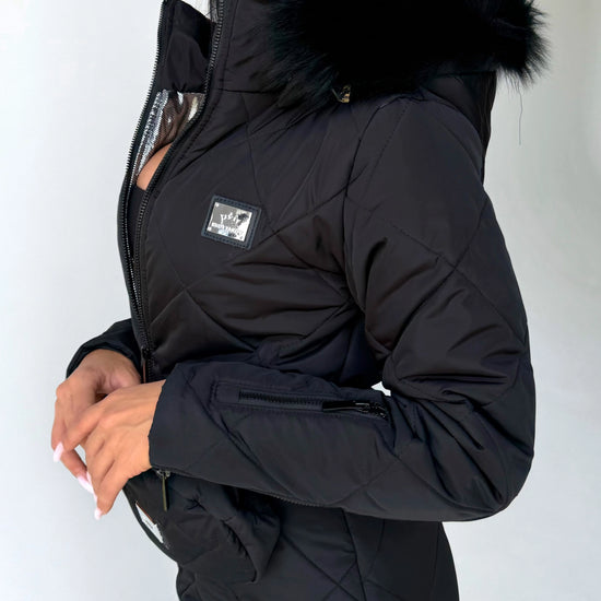 Women’s black ski suit detail with functional pockets and winter insulation