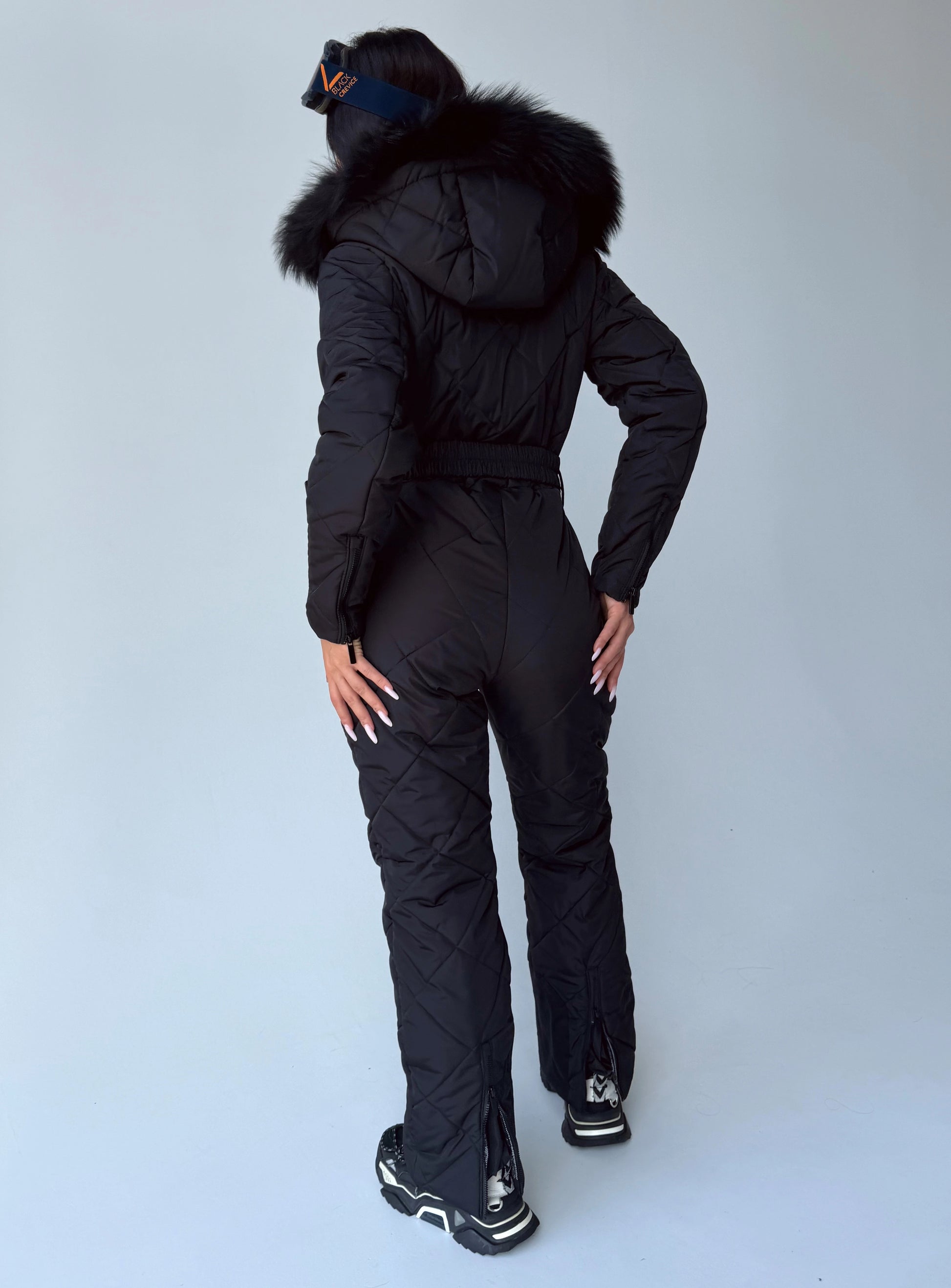 Back view of women’s black matte insulated one piece ski suit