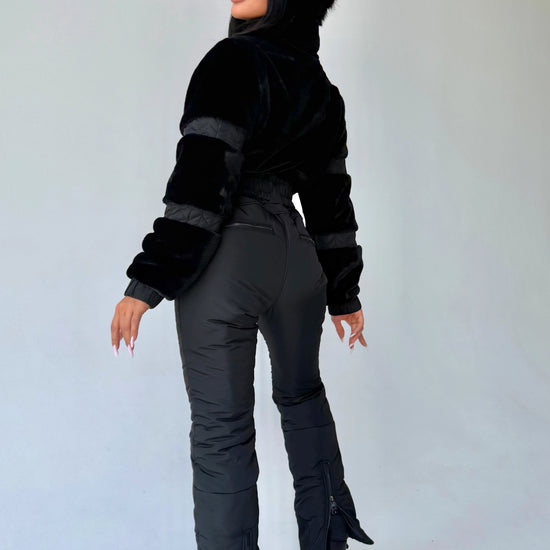 Side view of women’s black winter jumpsuit with eco fur by KRUTYAKOV
