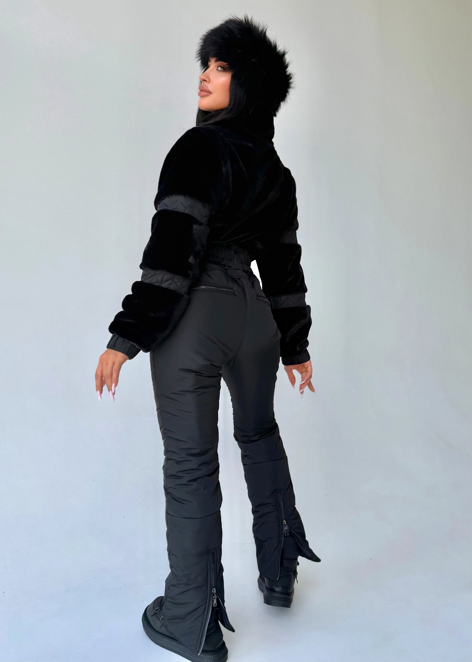 Side view of women’s black winter jumpsuit with eco fur by KRUTYAKOV