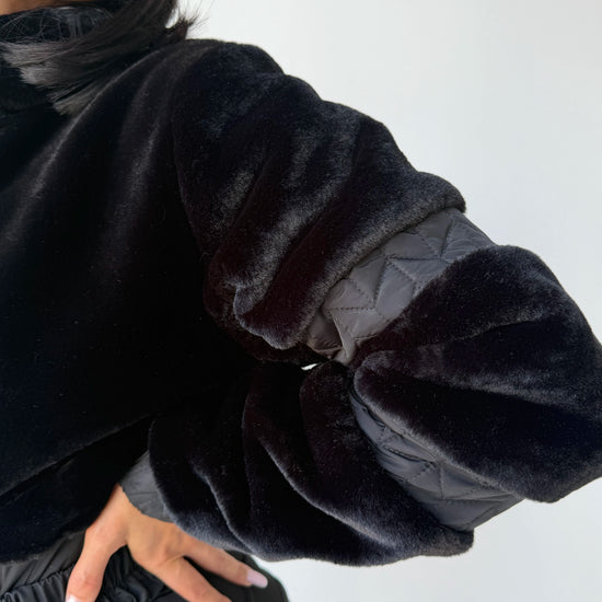 Black winter jumpsuit detail with eco fur texture and front zipper