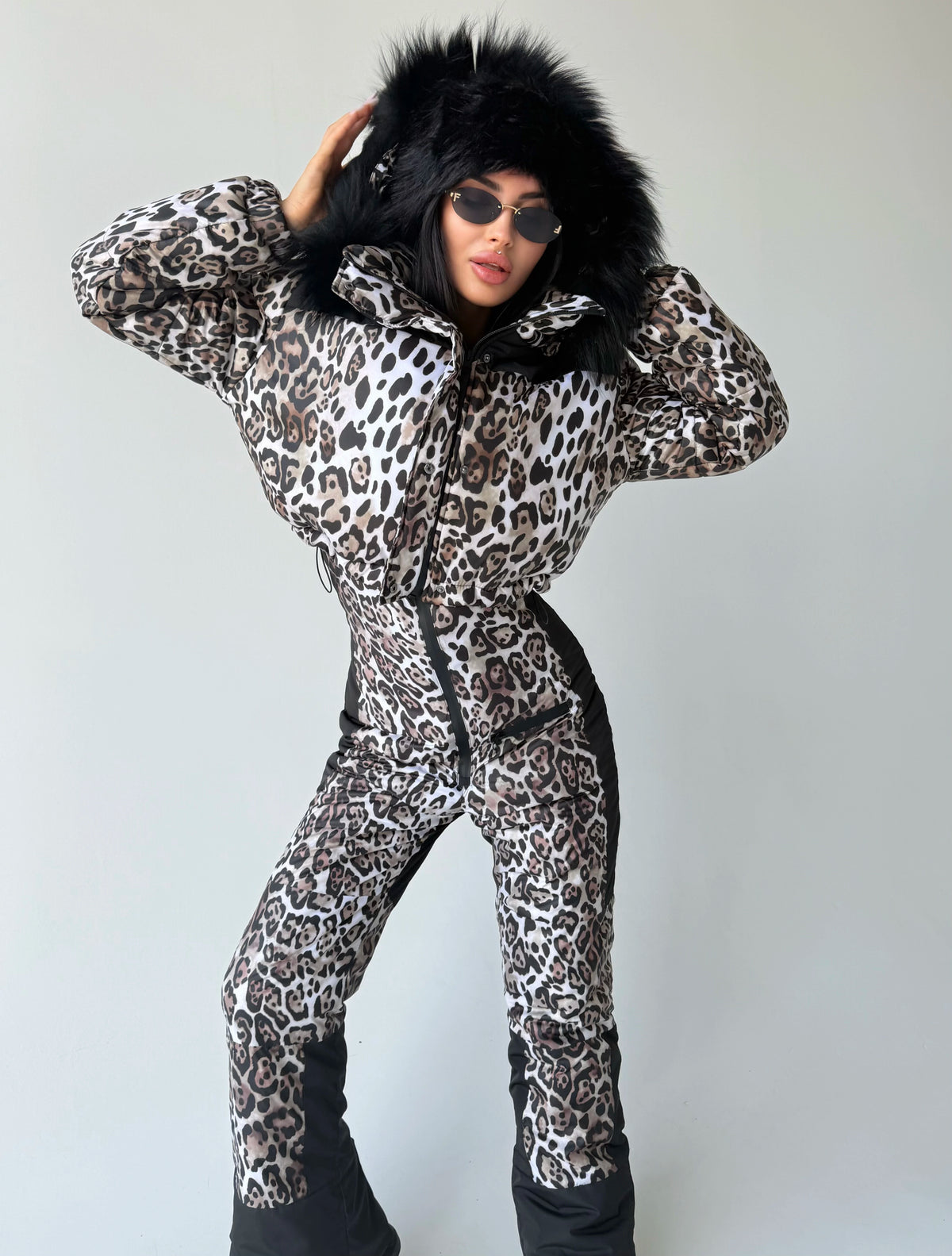 Women’s leopard winter ski suit with black fur hood and fitted silhouette