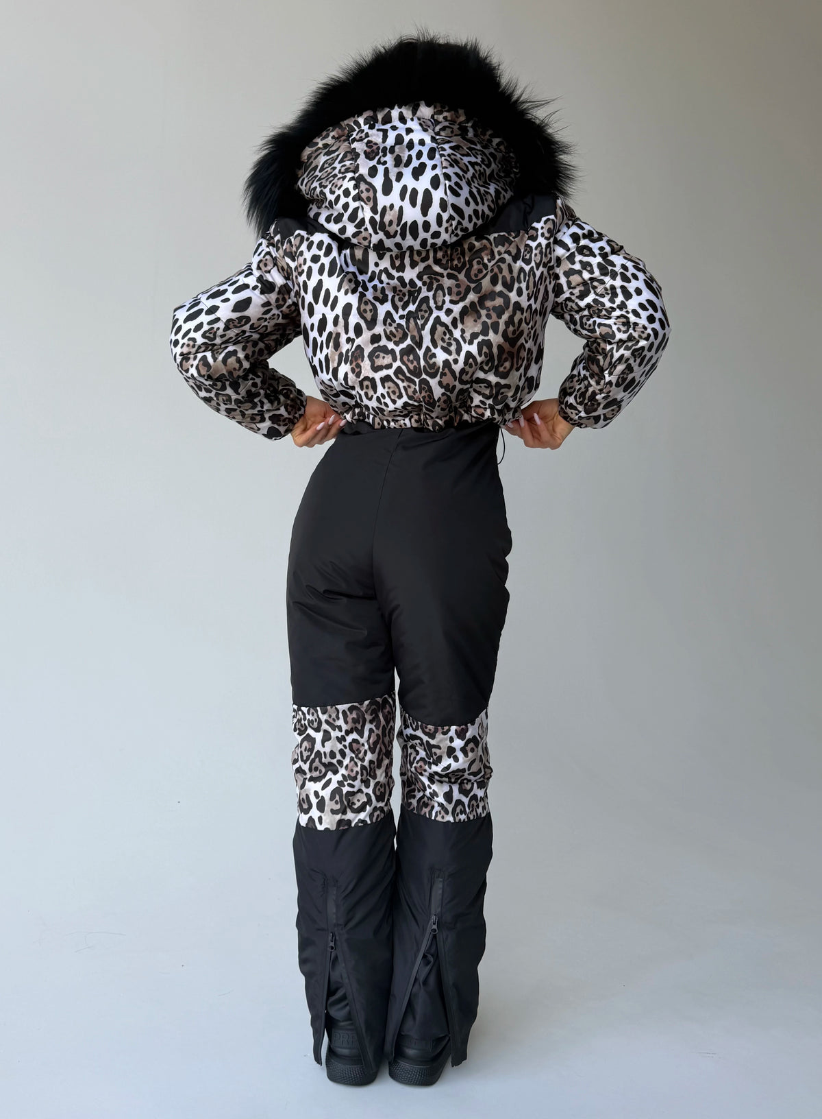 Front view of women’s leopard ski suit with fur-trimmed jacket