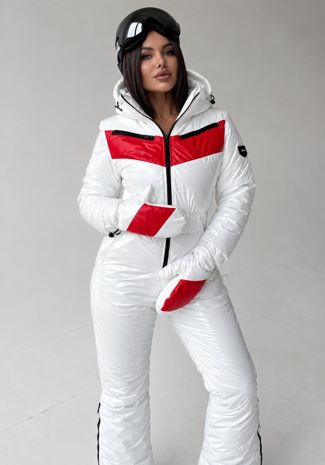Front view of white glossy women’s ski jumpsuit with red accents